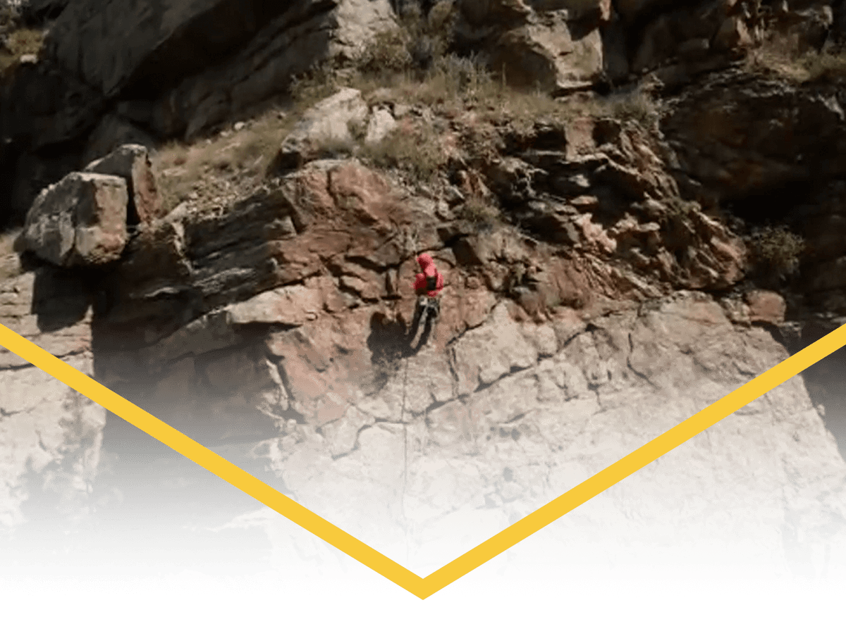 Kevin repelling down the cliff