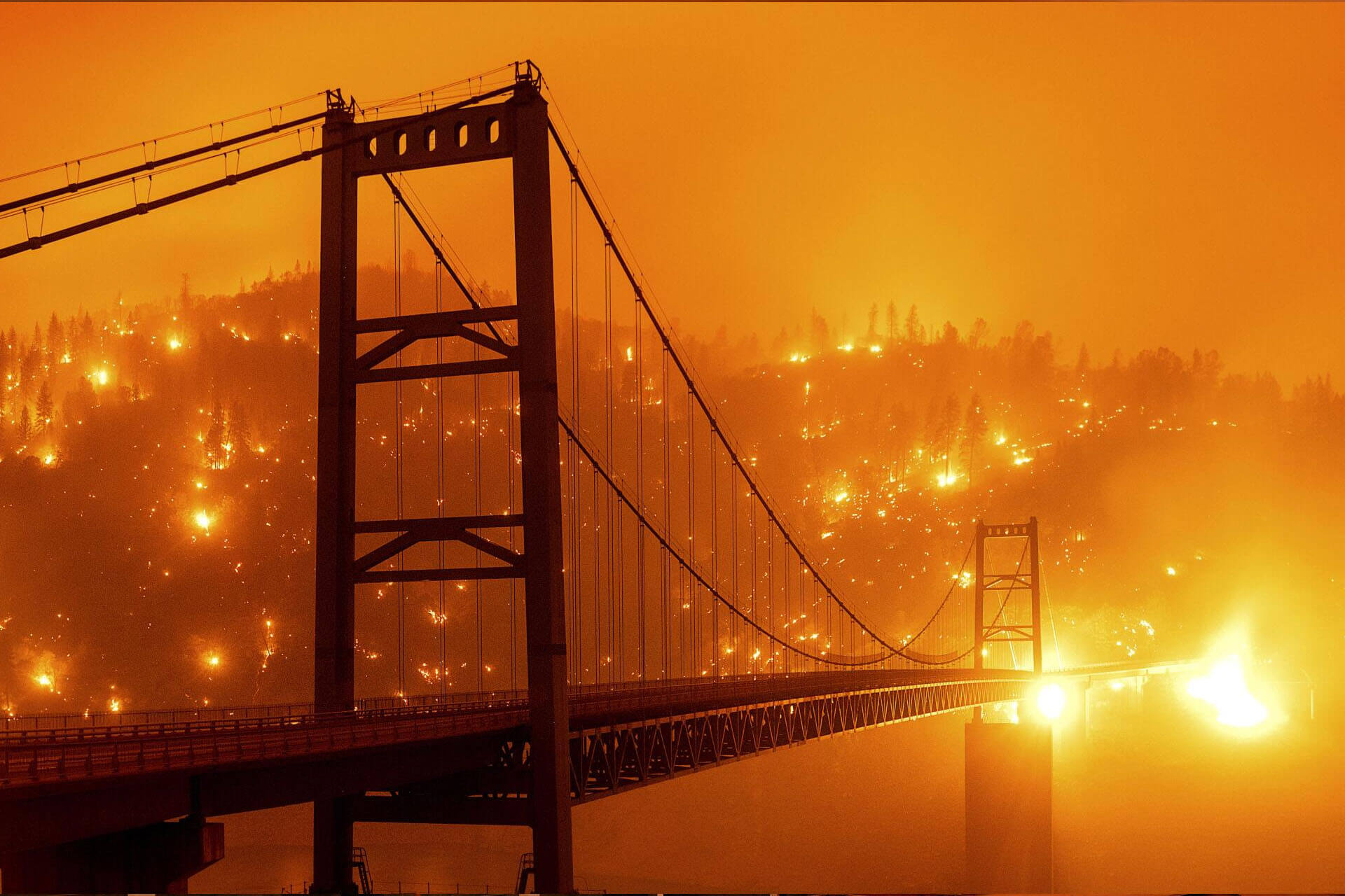 Hills on fire behind a bridge